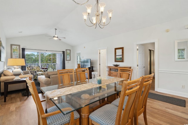 dining space with lofted ceiling, ceiling fan with notable chandelier, and light wood-type flooring