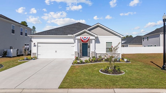 view of front of house with a garage, cooling unit, and a front yard