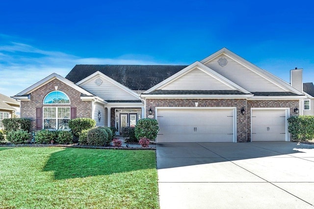 view of front facade featuring driveway, a chimney, a front yard, a garage, and brick siding