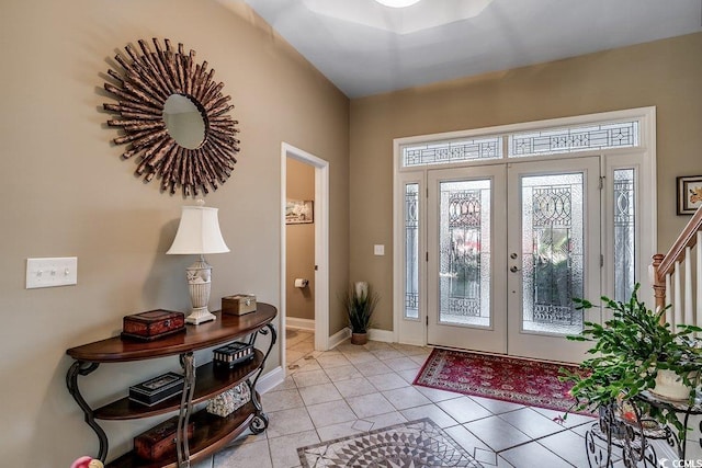entrance foyer with light tile patterned floors, baseboards, and french doors