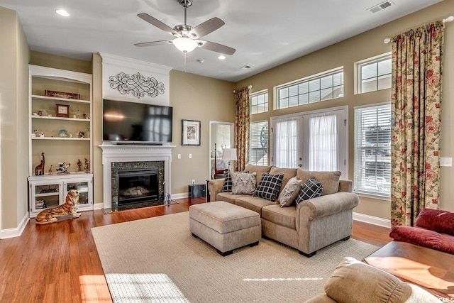 living room with visible vents, a healthy amount of sunlight, and wood finished floors