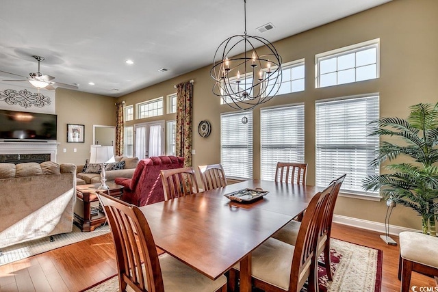 dining room featuring visible vents, wood finished floors, baseboards, ceiling fan with notable chandelier, and recessed lighting