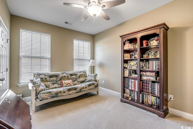 living area featuring visible vents, a ceiling fan, baseboards, and carpet floors