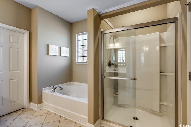 bathroom with a garden tub, a stall shower, baseboards, and tile patterned floors