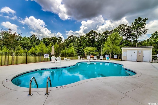 community pool featuring fence and a patio