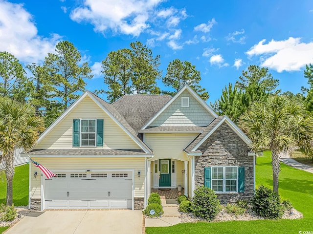 craftsman-style home featuring concrete driveway, a front yard, roof with shingles, a garage, and stone siding