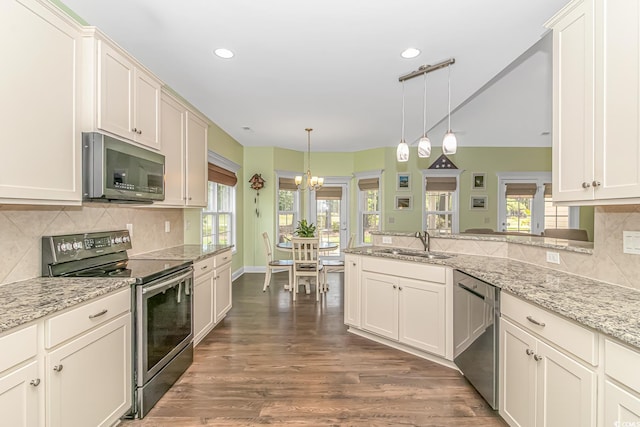 kitchen featuring a sink, decorative light fixtures, dark wood finished floors, stainless steel appliances, and decorative backsplash