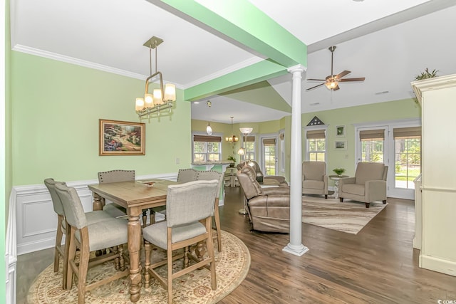 dining room with decorative columns, plenty of natural light, wood finished floors, and ceiling fan with notable chandelier