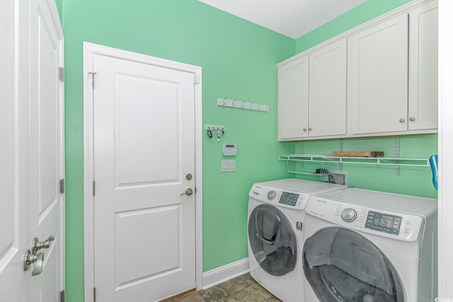 laundry area featuring washer and dryer, baseboards, and cabinet space