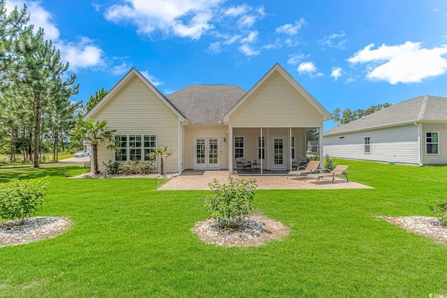 rear view of property with a lawn, french doors, a patio, and roof with shingles