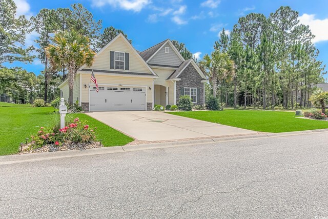 craftsman inspired home featuring stone siding, a garage, driveway, and a front lawn