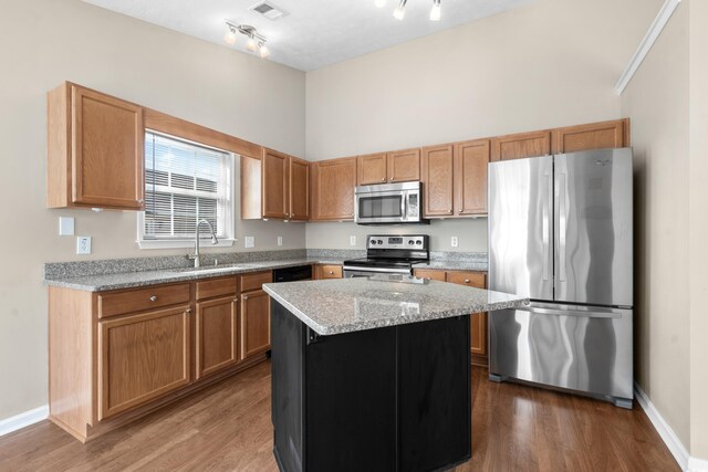 kitchen featuring sink, stainless steel appliances, a center island, and dark hardwood / wood-style flooring