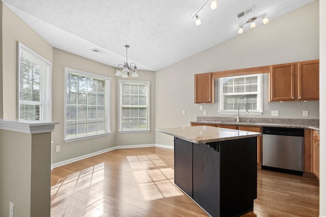 kitchen featuring a center island, decorative light fixtures, visible vents, vaulted ceiling, and dishwasher