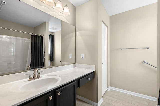 bathroom with visible vents, baseboards, a shower with shower curtain, wood finished floors, and vanity