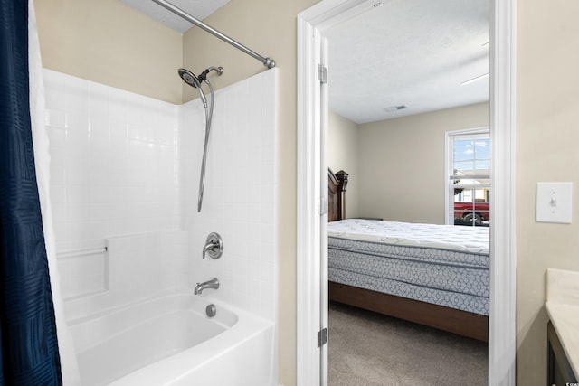 ensuite bathroom featuring visible vents, shower / bath combo with shower curtain, connected bathroom, a textured ceiling, and vanity