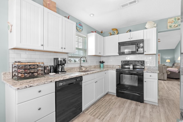 2169 Wedgewood Dr, Longs, SC 29568 - kitchen with black appliances, white cabinetry, light wood-style floors, and decorative backsplash