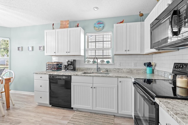 2169 Wedgewood Dr, Longs, SC 29568 - kitchen featuring black appliances, decorative backsplash, a textured ceiling, white cabinetry, and light wood-style floors