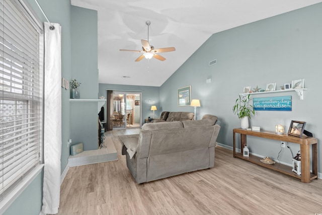 living area with ceiling fan, high vaulted ceiling, wood finished floors, visible vents, and baseboards