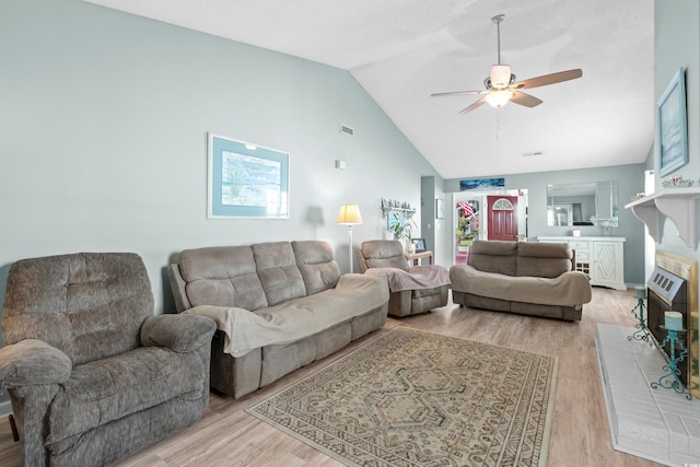 living area featuring high vaulted ceiling, light wood-style floors, visible vents, and a ceiling fan