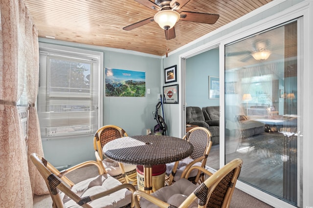 interior space featuring plenty of natural light, wood ceiling, ornamental molding, and a ceiling fan