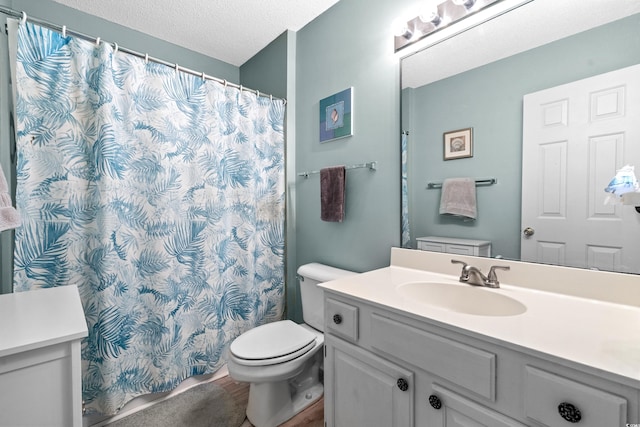 full bath featuring a textured ceiling, a shower with shower curtain, vanity, and toilet