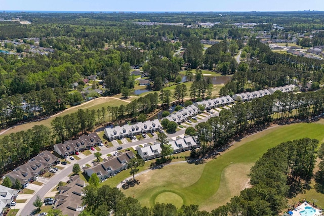 drone / aerial view with view of golf course, a residential view, and a wooded view