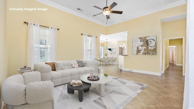 tiled living room with ceiling fan and crown molding