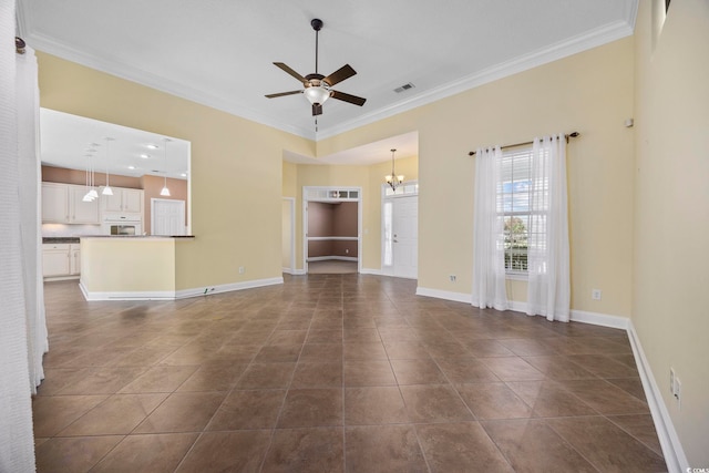 unfurnished living room featuring dark tile patterned floors, ornamental molding, and ceiling fan with notable chandelier