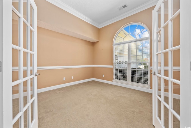 carpeted spare room featuring a textured ceiling, french doors, and crown molding