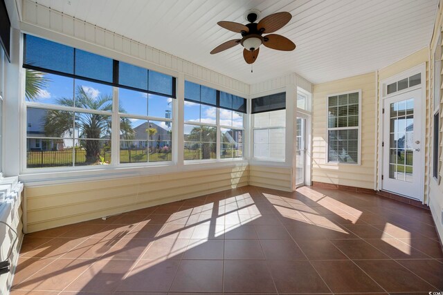 unfurnished sunroom featuring ceiling fan