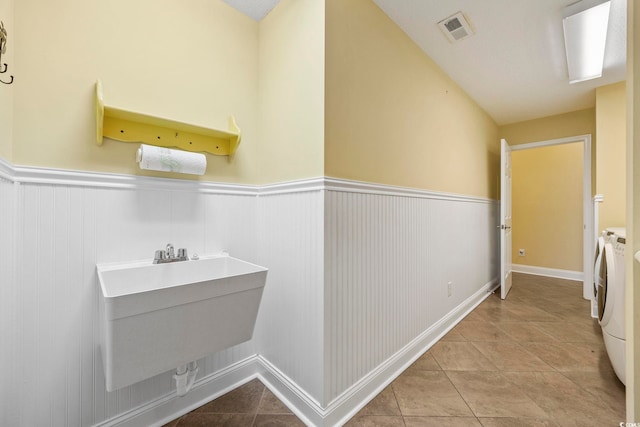 bathroom with washing machine and dryer and tile patterned floors