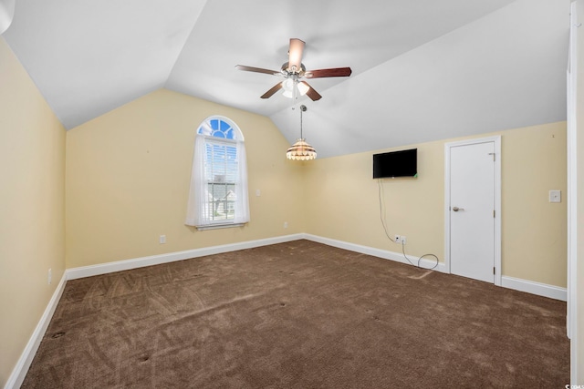 carpeted spare room featuring ceiling fan and vaulted ceiling