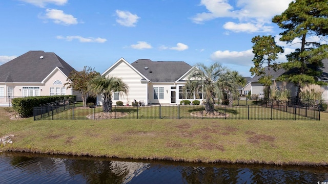 rear view of house featuring a lawn and a water view