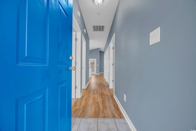 hallway featuring a textured ceiling and light wood-type flooring