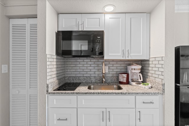 9550 Shore Dr Unit 1202, Myrtle Beach, SC 29572 - kitchen featuring black appliances, a sink, white cabinetry, backsplash, and a textured ceiling