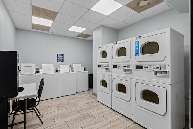 washroom with washer and dryer, light hardwood / wood-style floors, and stacked washing maching and dryer