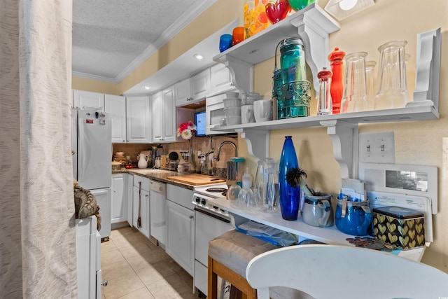 kitchen with ornamental molding, white cabinets, a textured ceiling, and white appliances