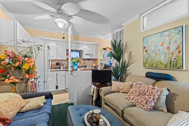 living room with crown molding, light tile patterned flooring, a textured ceiling, and ceiling fan