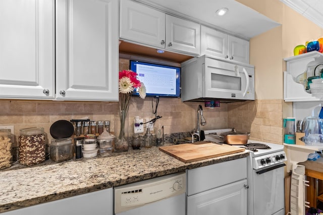 kitchen featuring white appliances, backsplash, and white cabinets