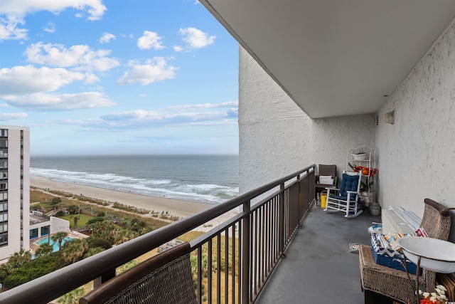 balcony featuring a water view and a view of the beach