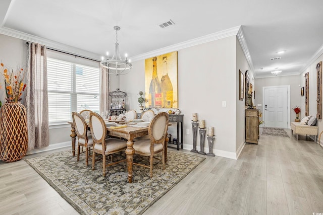 dining room with ornamental molding, a notable chandelier, and light wood-type flooring