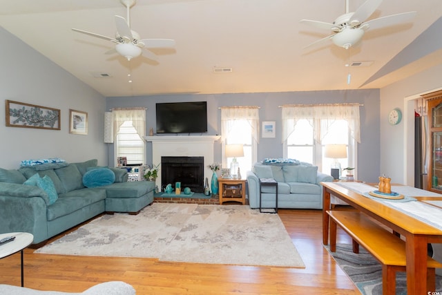 living room featuring vaulted ceiling, light hardwood / wood-style floors, and ceiling fan