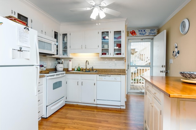 kitchen with a sink, white appliances, ornamental molding, decorative backsplash, and light wood-style floors