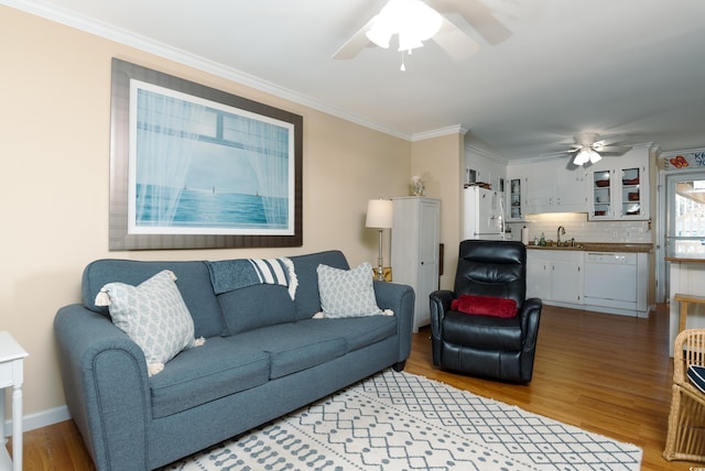 living room featuring ornamental molding, sink, hardwood / wood-style flooring, and ceiling fan