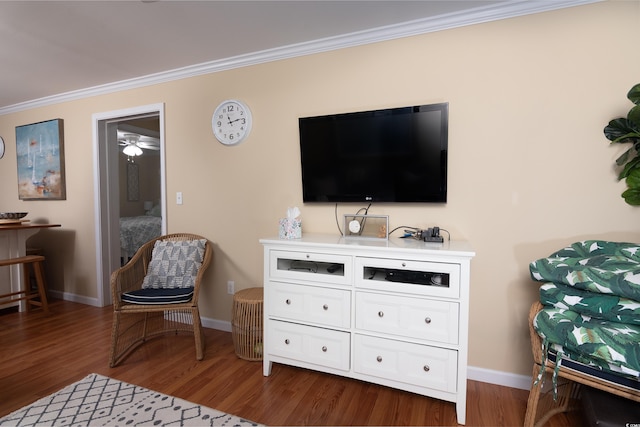 sitting room with ornamental molding, dark wood-type flooring, and ceiling fan