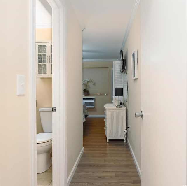 corridor with wood-type flooring, ornamental molding, and a wall unit AC