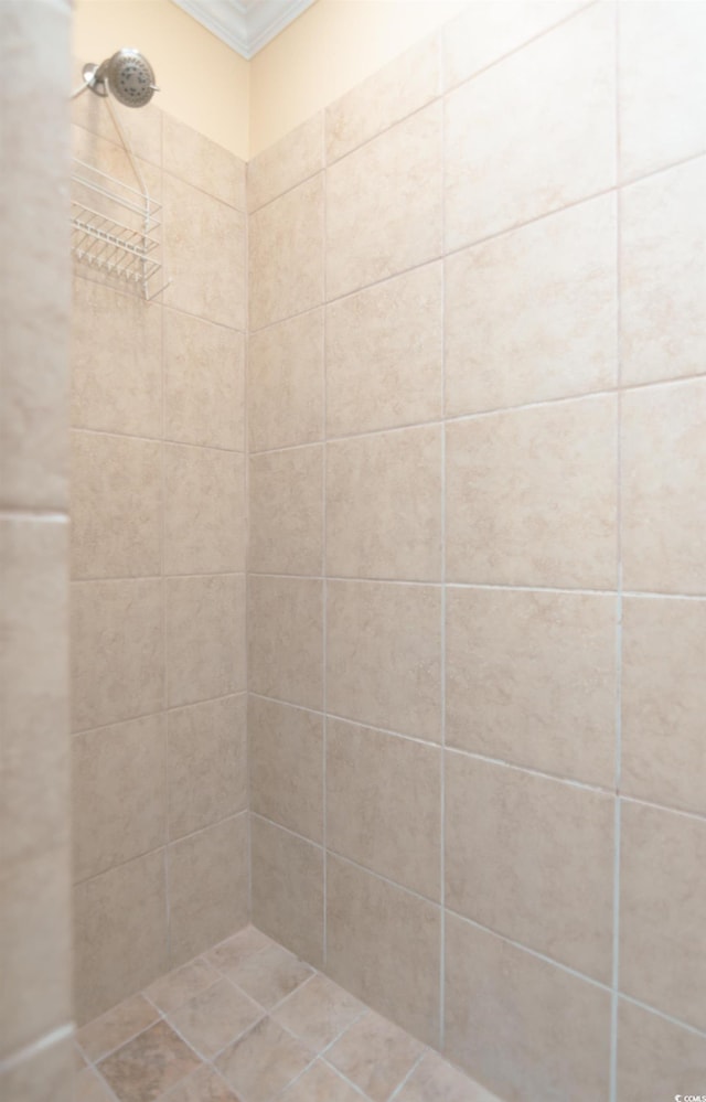 full bath featuring ornamental molding and tiled shower
