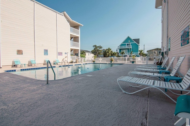 pool featuring fence and a patio