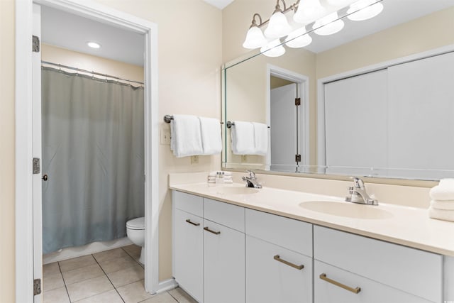 bathroom with tile patterned flooring, vanity, and toilet