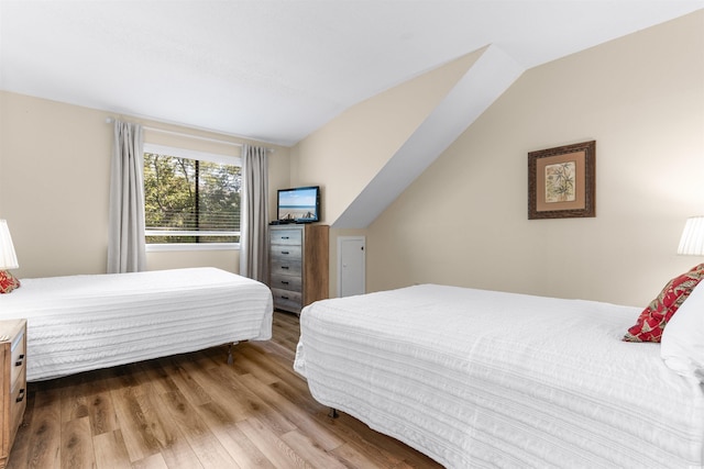 bedroom featuring lofted ceiling and light wood-type flooring